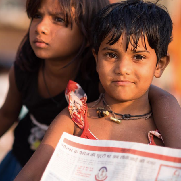 Street children in India reading the newspaper