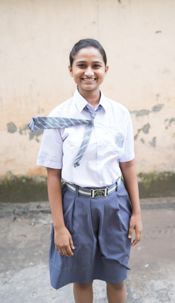 Happy Indian girl student posing for picture in uniform