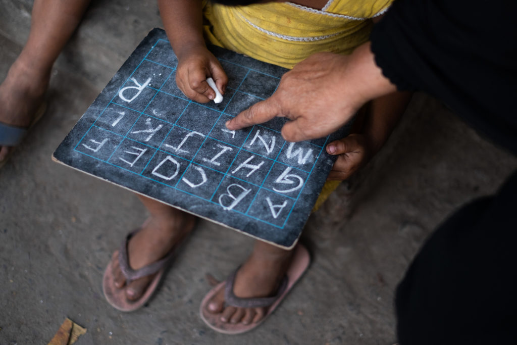 Indian child learning English ABCs on chalk board