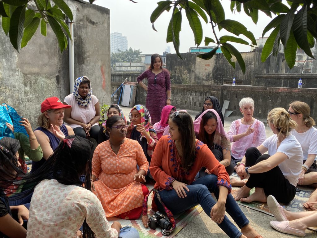 Volunteers in India hanging out with women from Her Future Coalition's Jewelry Program